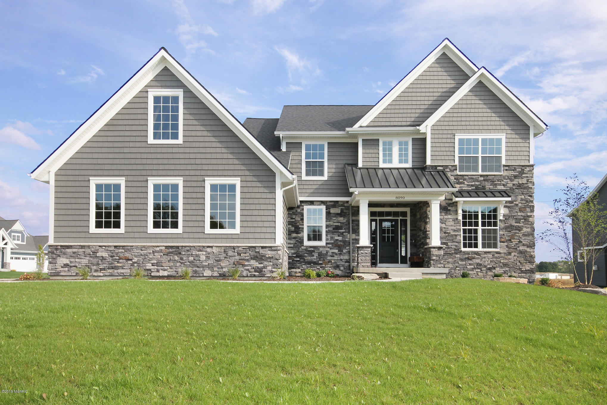 New custom home with dark beige siding and stone detailing