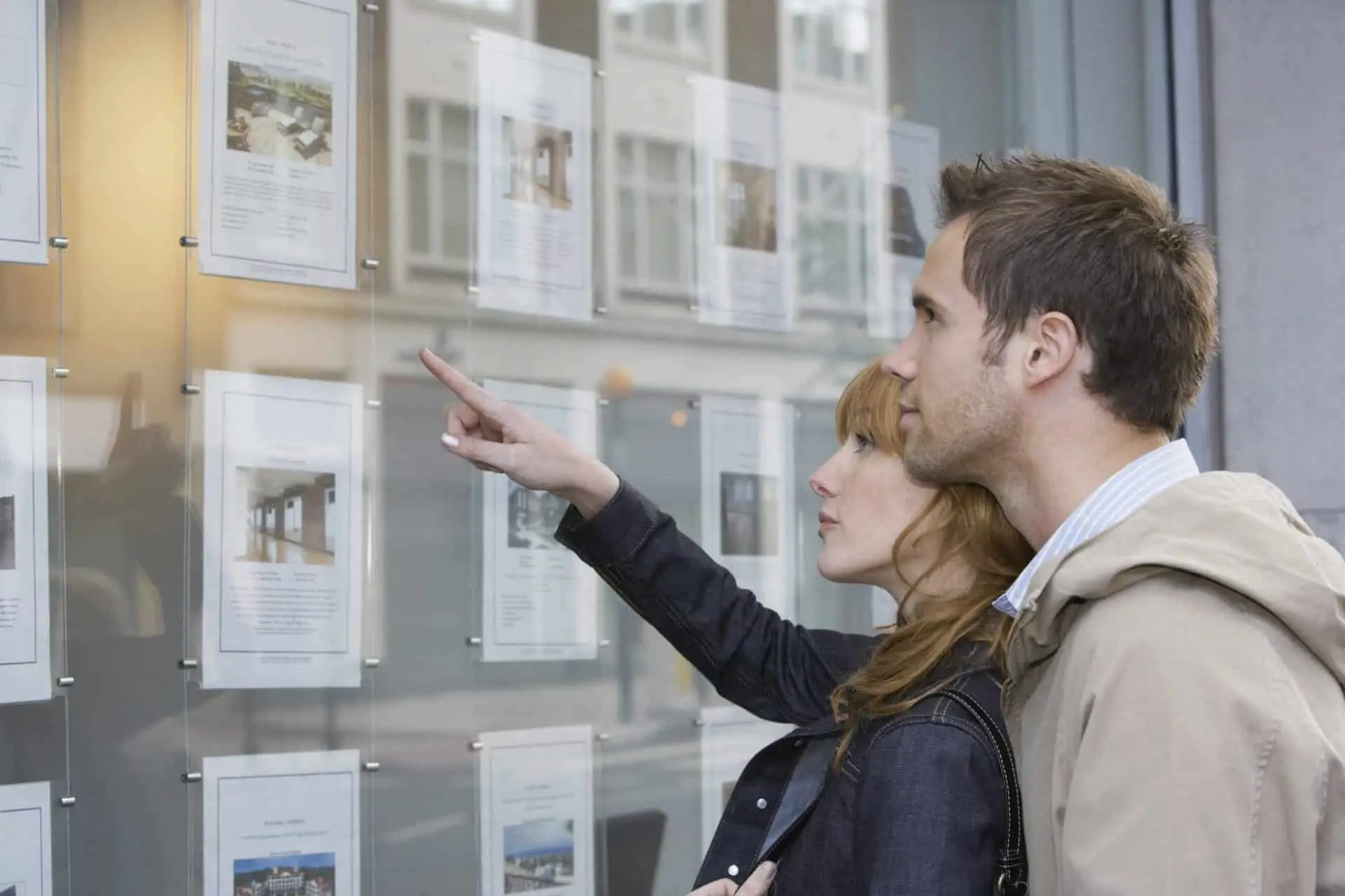 A young couple checking real estate office listings.
